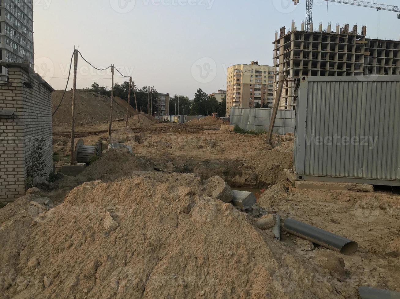 zand Bij een bouw plaats. bouw van een nieuw microdistrict in de stad centrum. beton huizen, blok identiek gebouwen. grijs huizen, menselijk bewoning foto