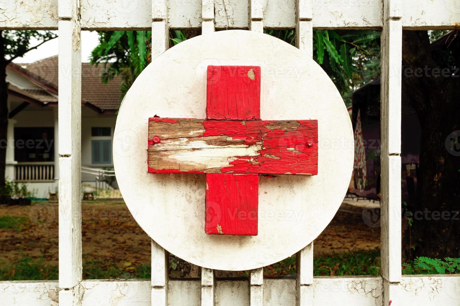 rood en wit houten kruis in de buurt naar kliniek. medisch symbool. foto
