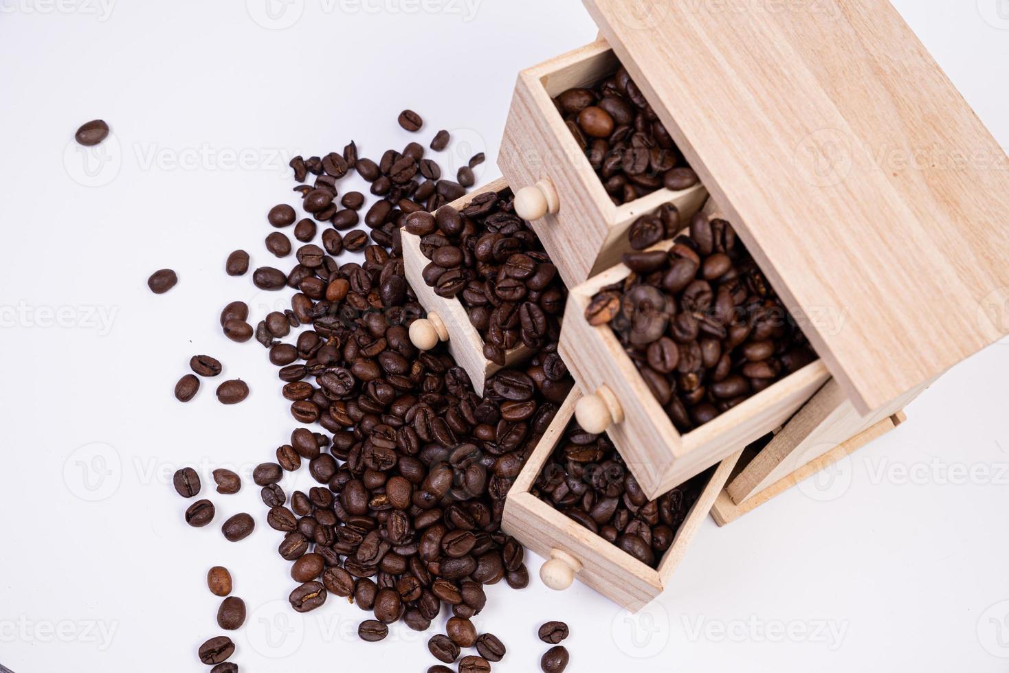 houten doos met cellen gevulde met koffie bonen. koffie bonen verspreide kant door kant geïsoleerd Aan wit achtergrond foto