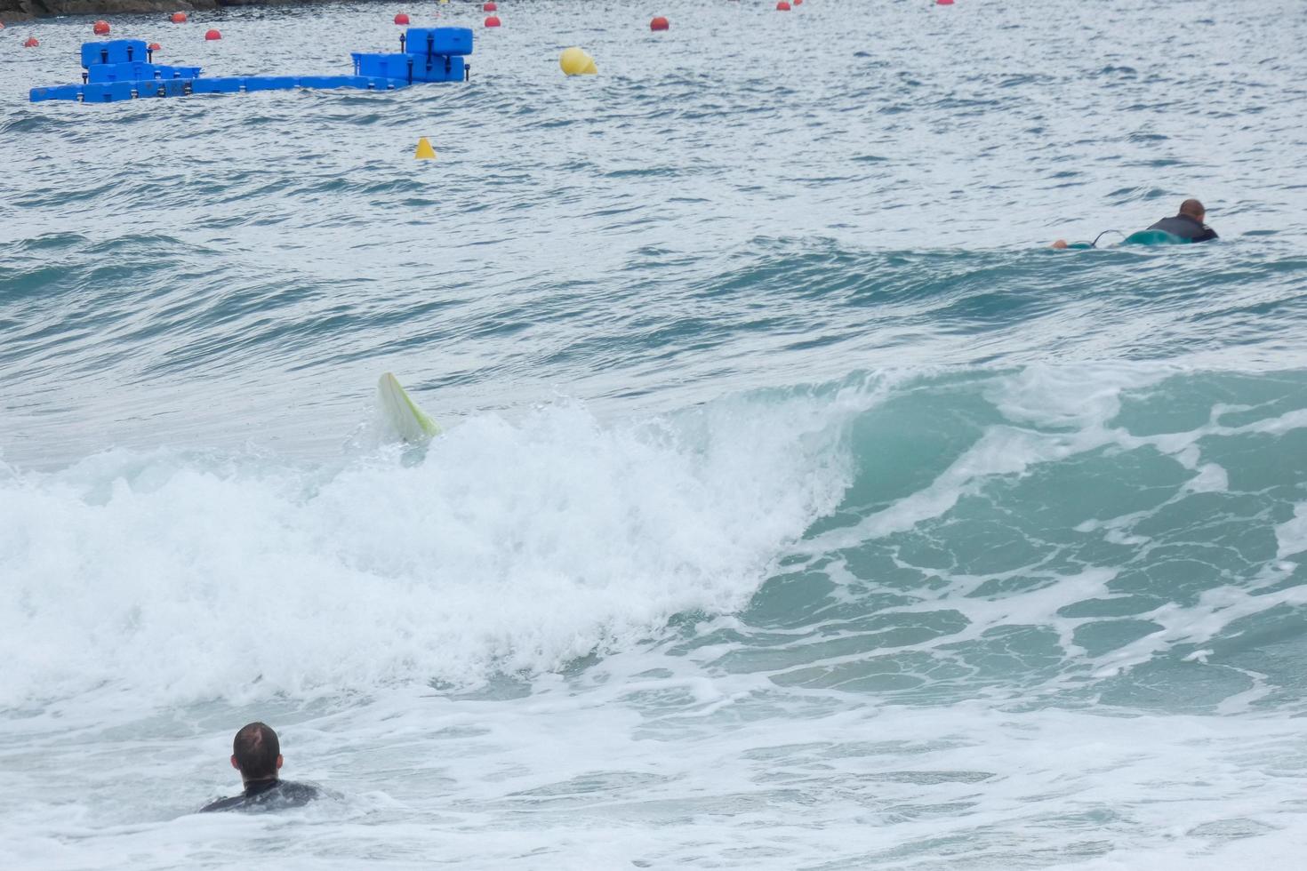 surfers rijden golven in een stormachtig zee foto