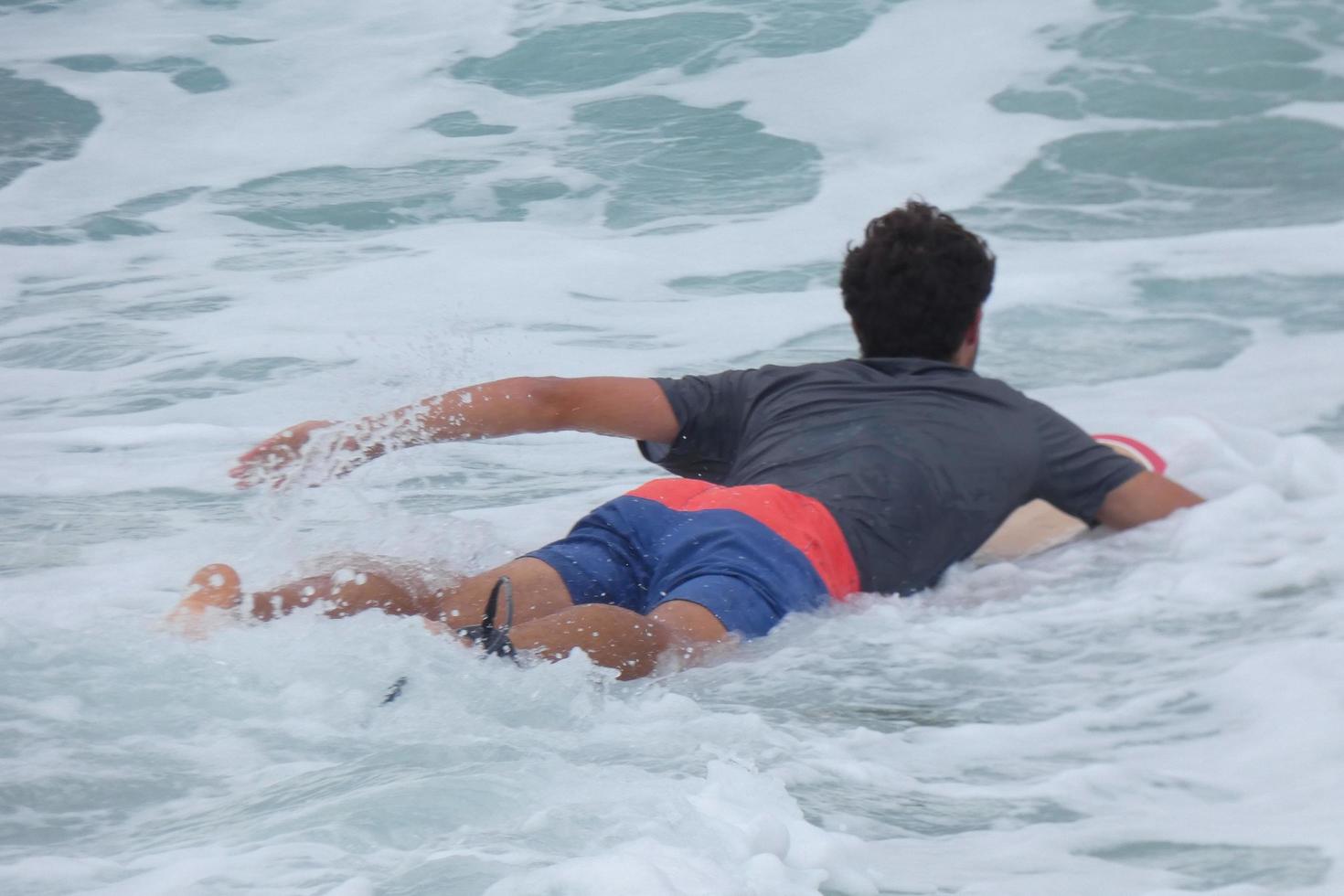 surfers nemen voordeel van klein golven foto