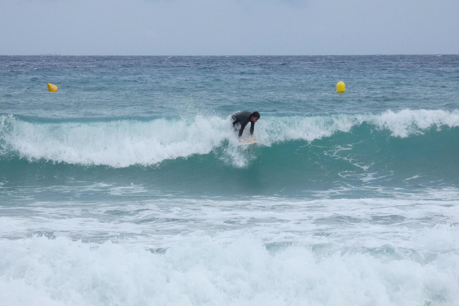 surfers rijden golven in een stormachtig zee foto