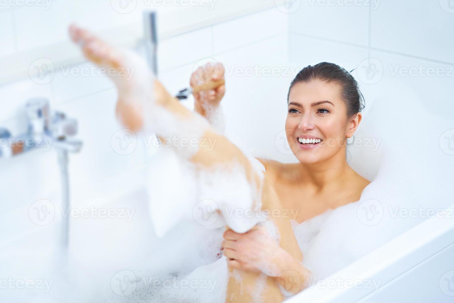 jong mooi hoor brunette vrouw hebben bad in bad foto