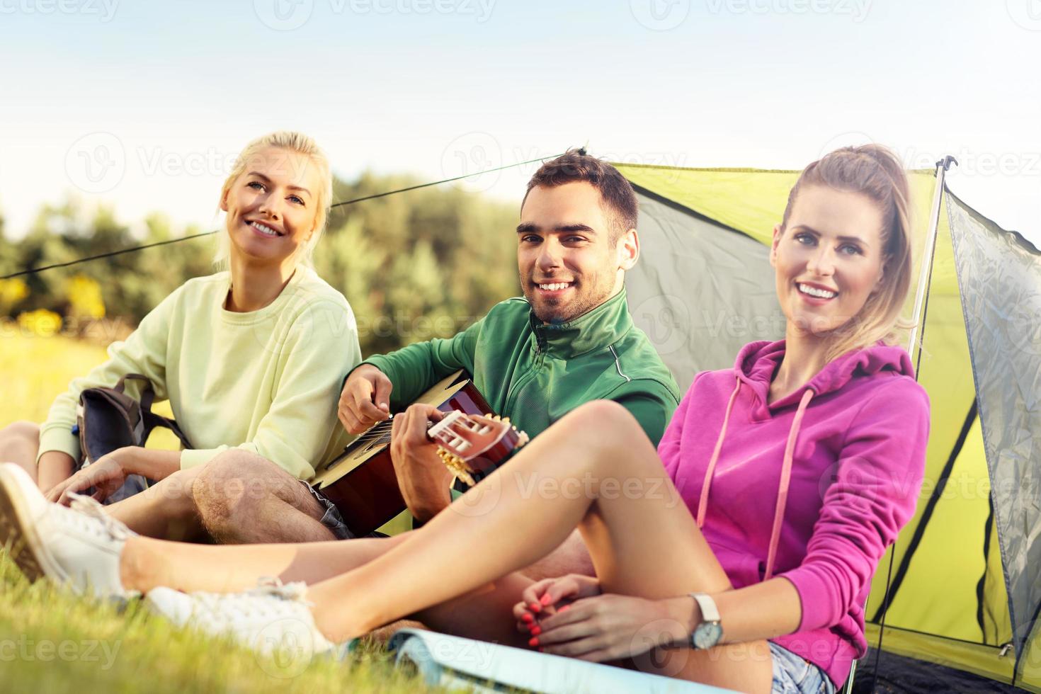 groep van vrienden camping in Woud en spelen gitaar foto