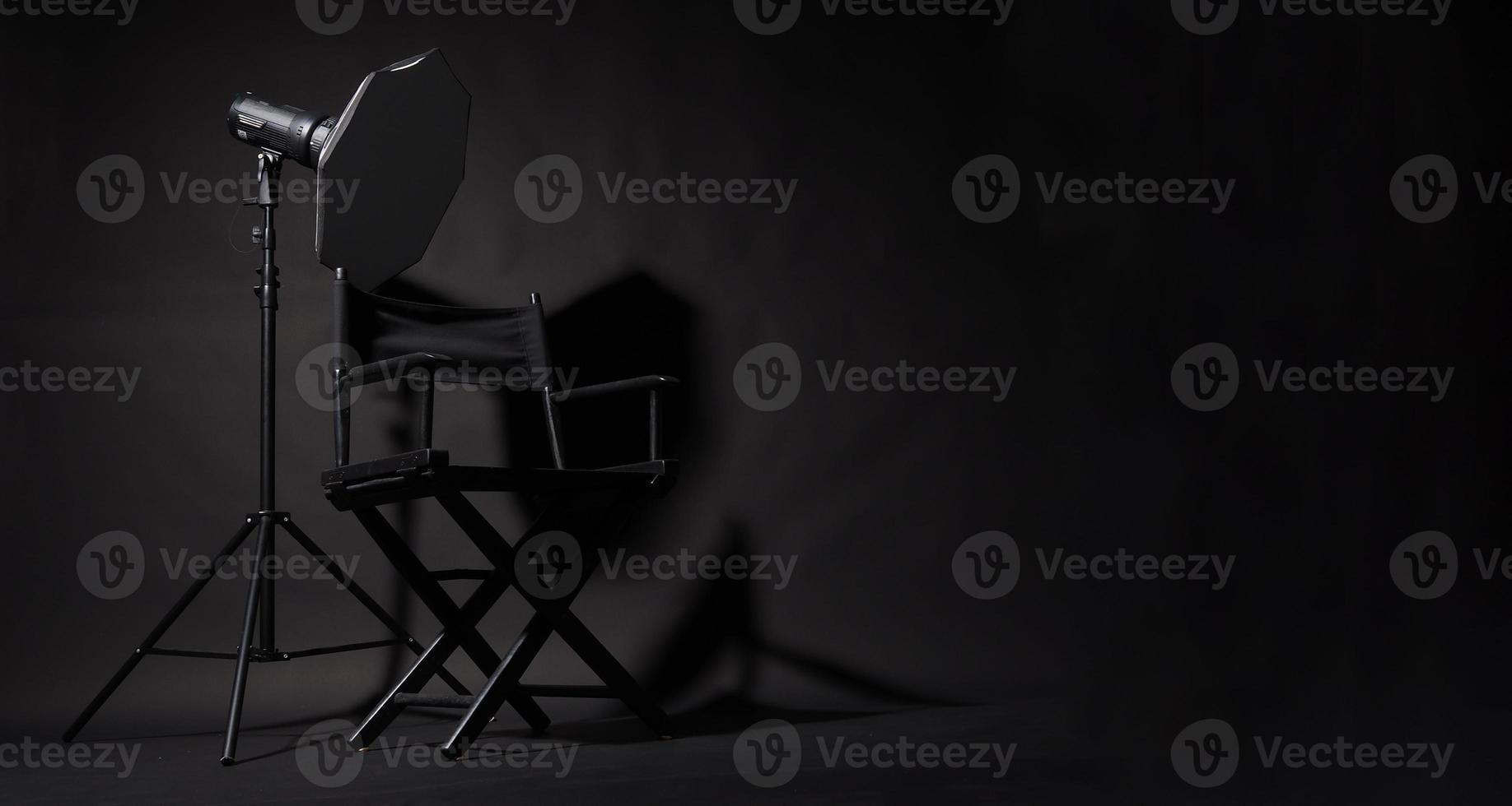 zwart regisseur stoel en studio licht Aan zwart achtergrond. foto