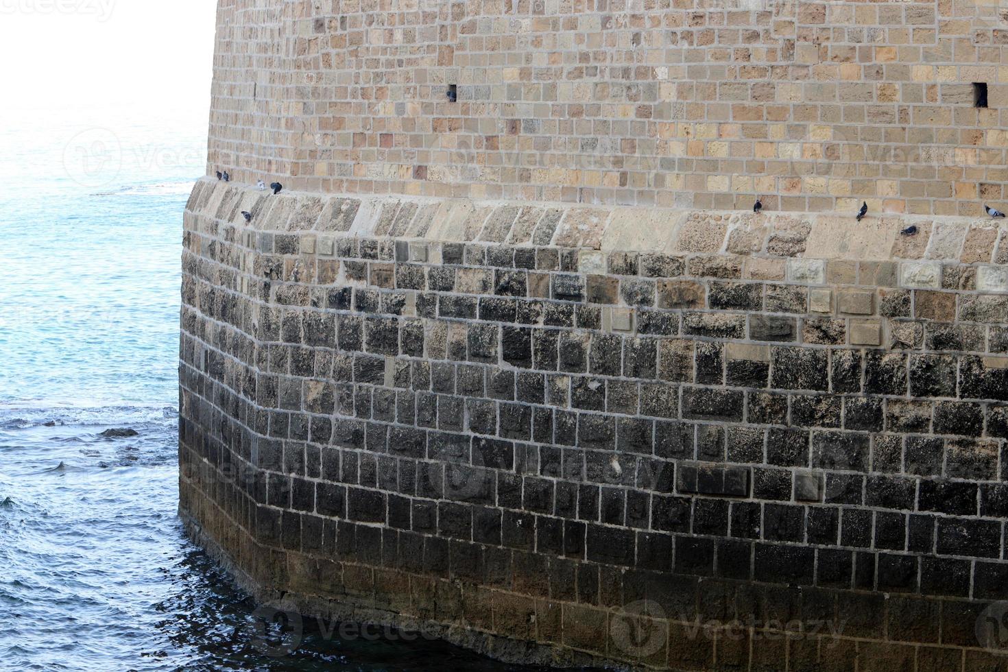 steen muur van een oude vesting Aan de kust in Israël. foto