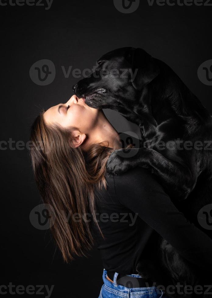 een meisje houdt een labrador retriever-hond in haar armen. foto