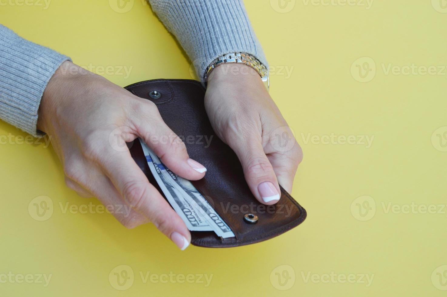 vrouwen handen zetten geld in een portemonnee. nemen uit bankbiljetten van de portemonnee. foto