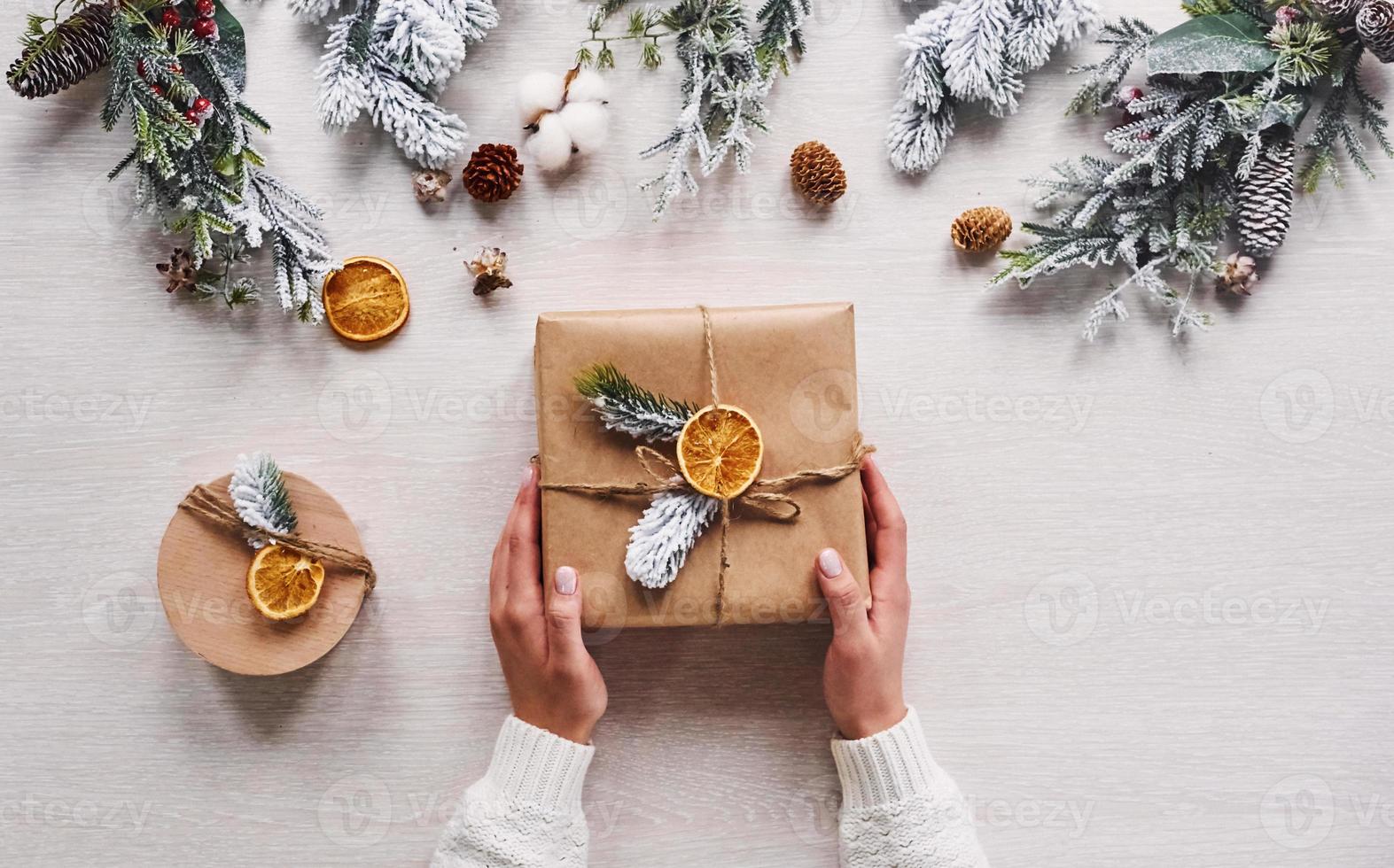 meisje maken geschenk doos. top visie van Kerstmis feestelijk kader met nieuw jaar decoraties foto