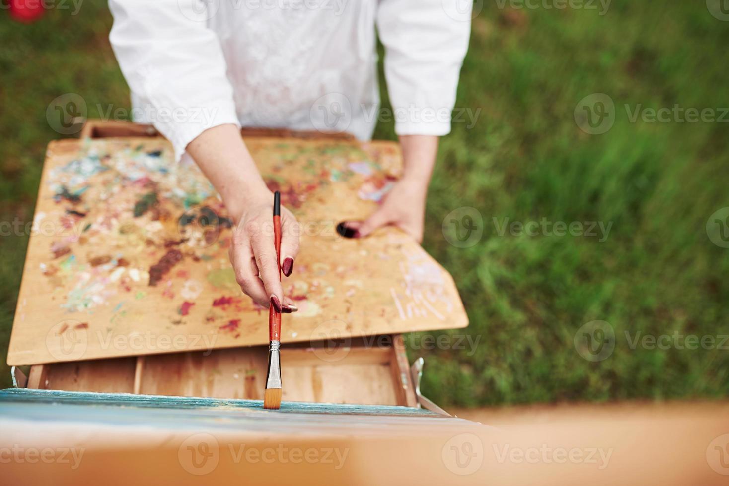 buiten staan. conceptie van schilderen. foto van de hand van de vrouw met rode borstel