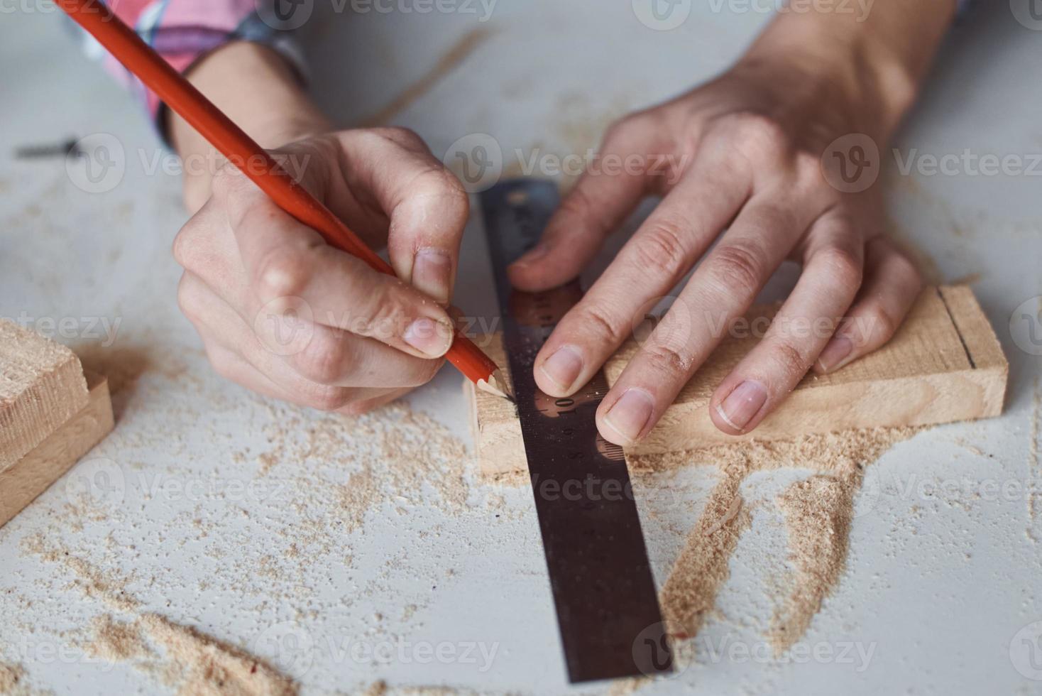 timmerman handen nemen meting met een potlood van houten plank. foto