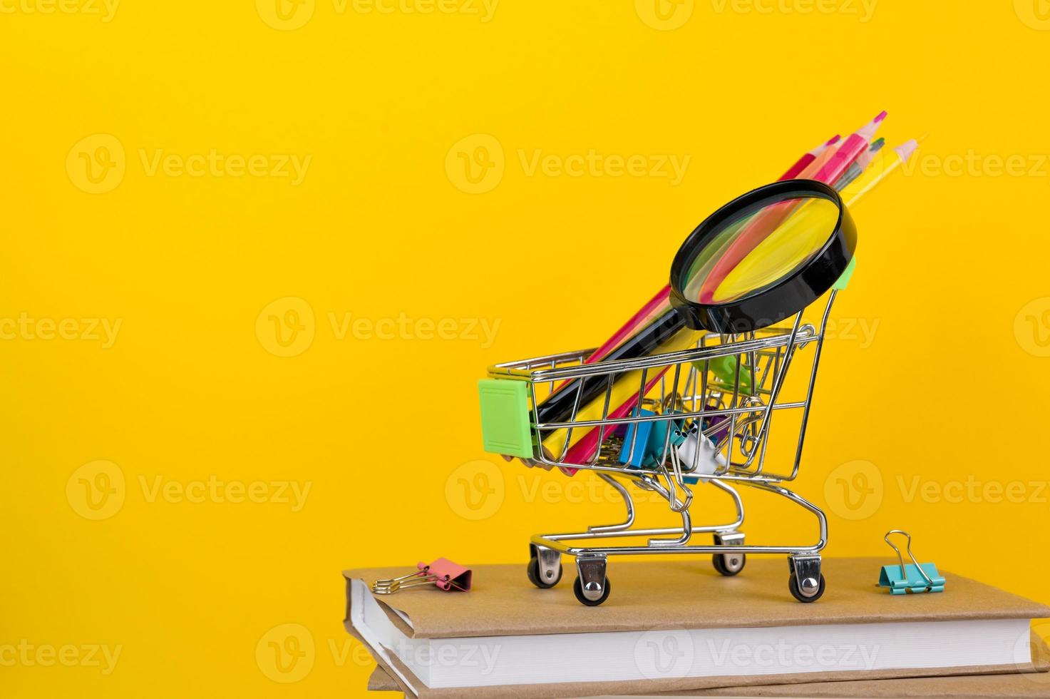 banier met plaats voor tekst. school- benodigdheden in boodschappen doen kar Aan stapel van boeken. foto