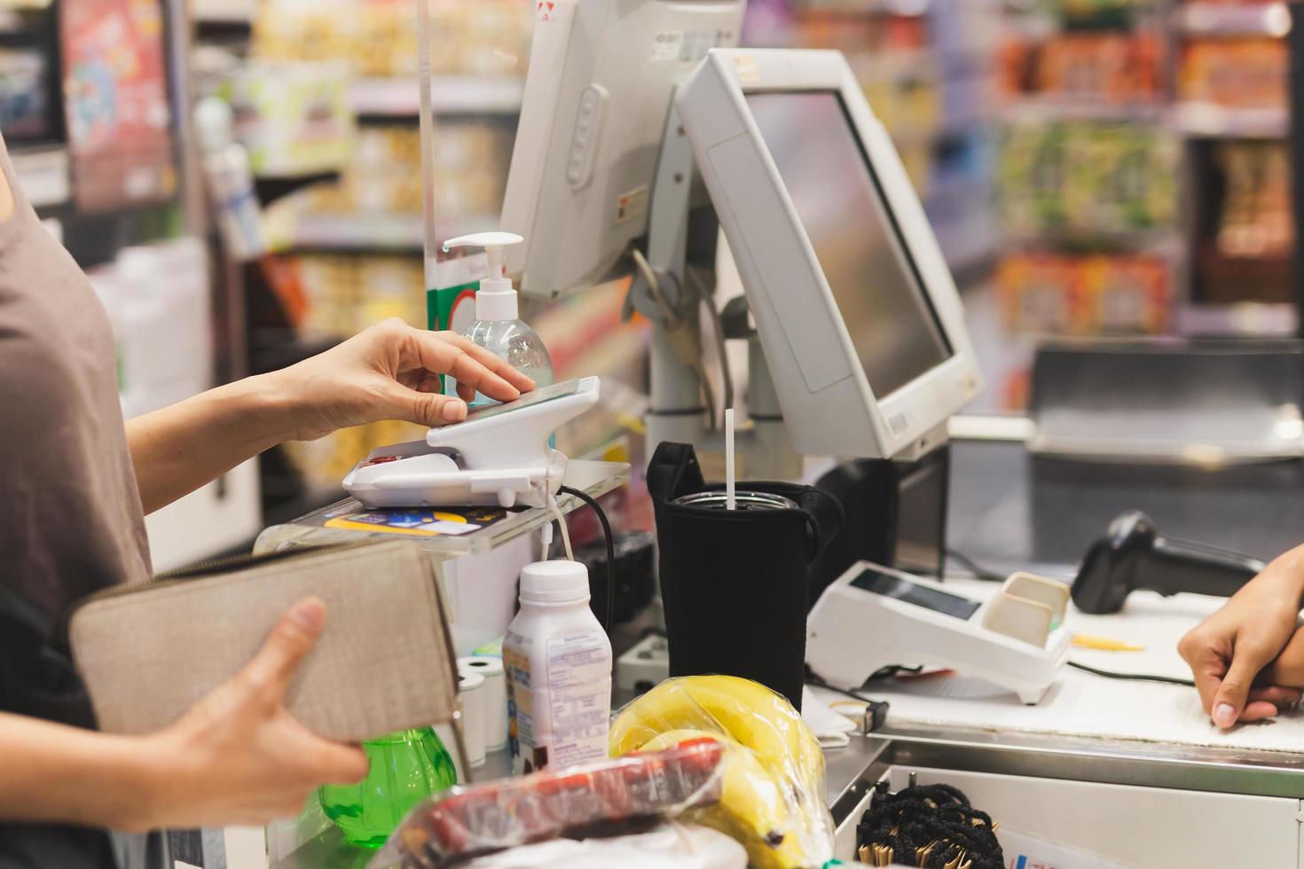 vrouw klant betalen via credit kaart gebruik makend van nfc technologie in boodschappen doen winkelcentrum. foto