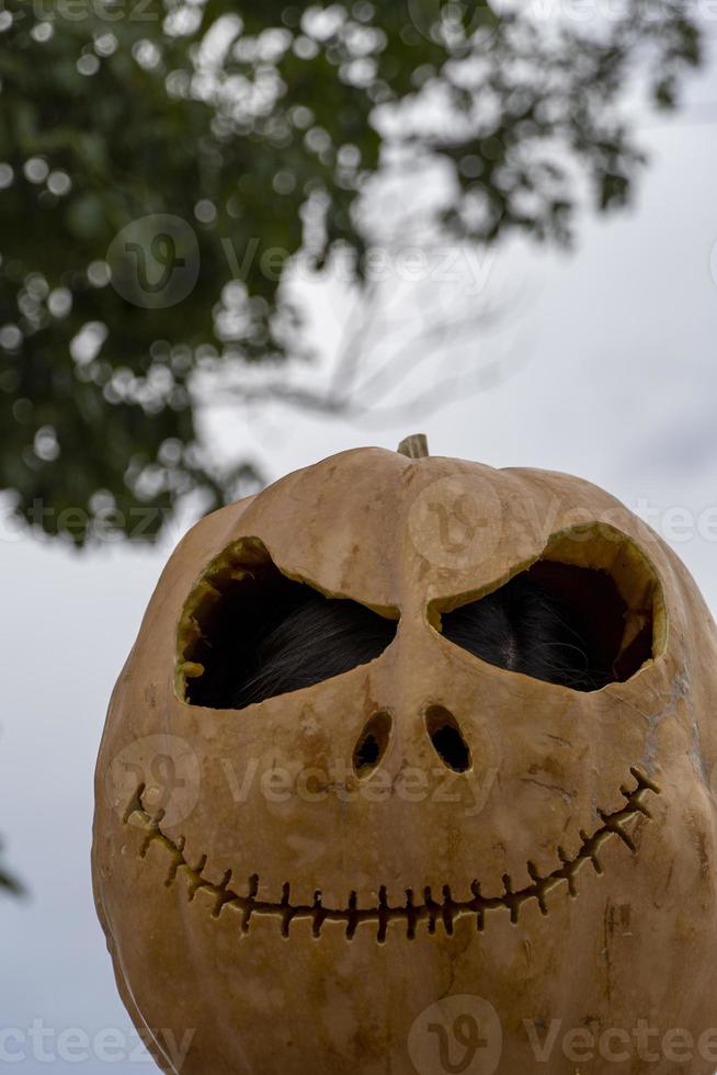 jong vrouw met een pompoen Aan haar hoofd voor halloween, dag van de dood, Mexico foto