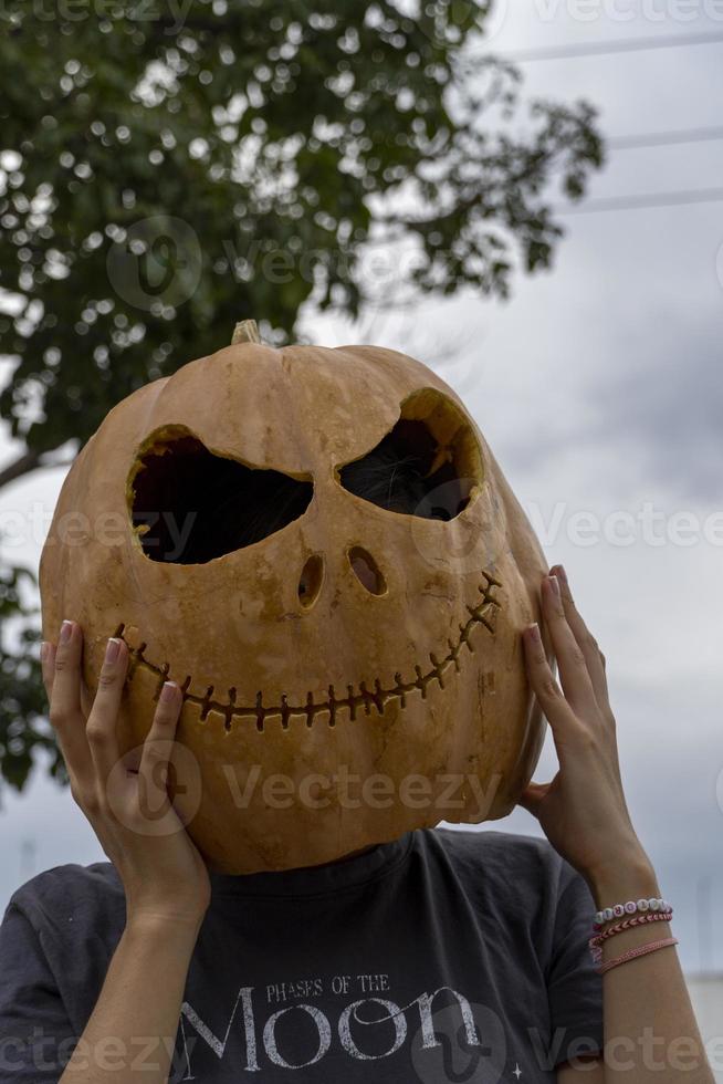 jong vrouw met een pompoen Aan haar hoofd voor halloween, dag van de dood, Mexico foto