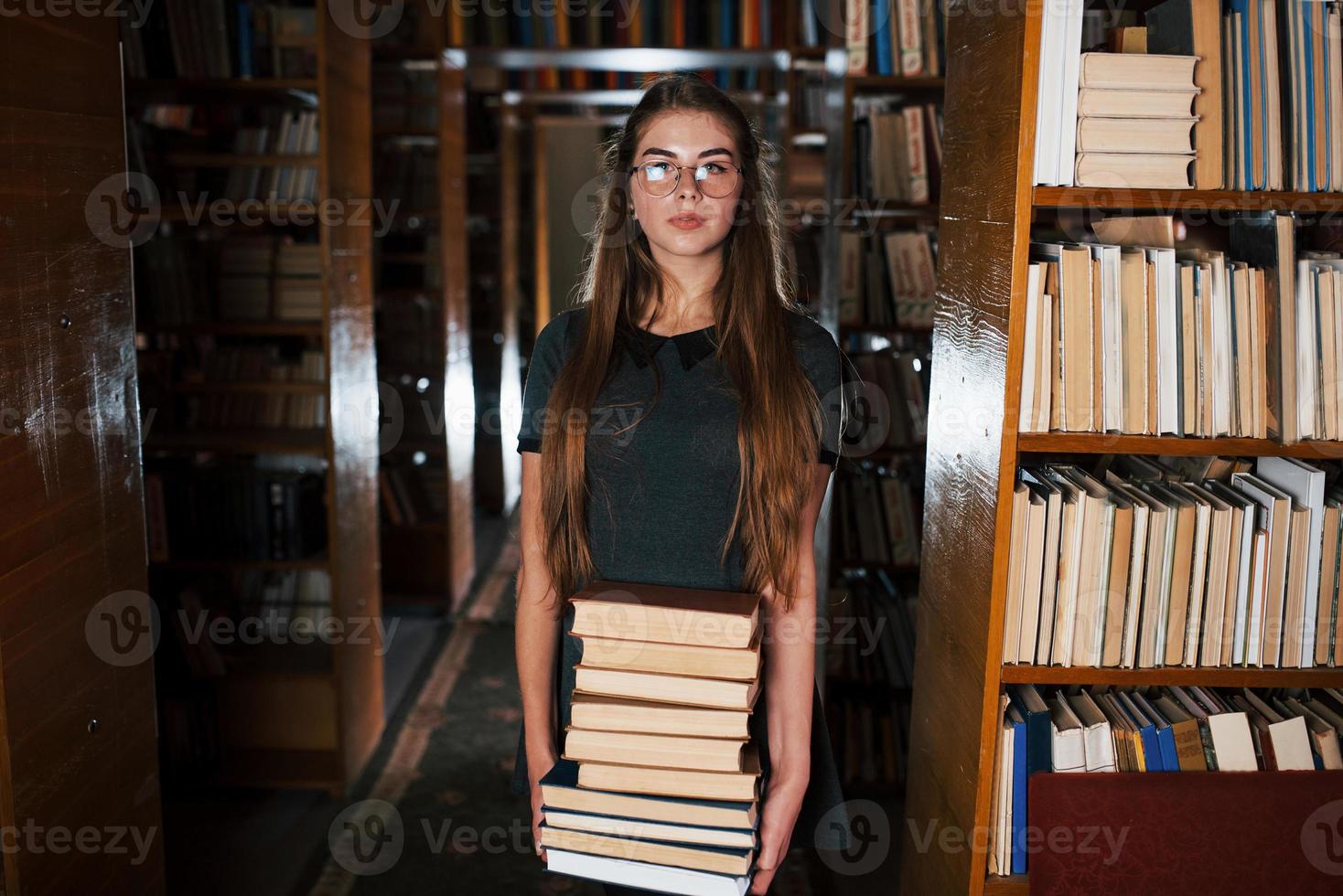 Daar is een veel van informatie in dat boeken dat in handen. vrouw leerling is in bibliotheek. opvatting van onderwijs foto