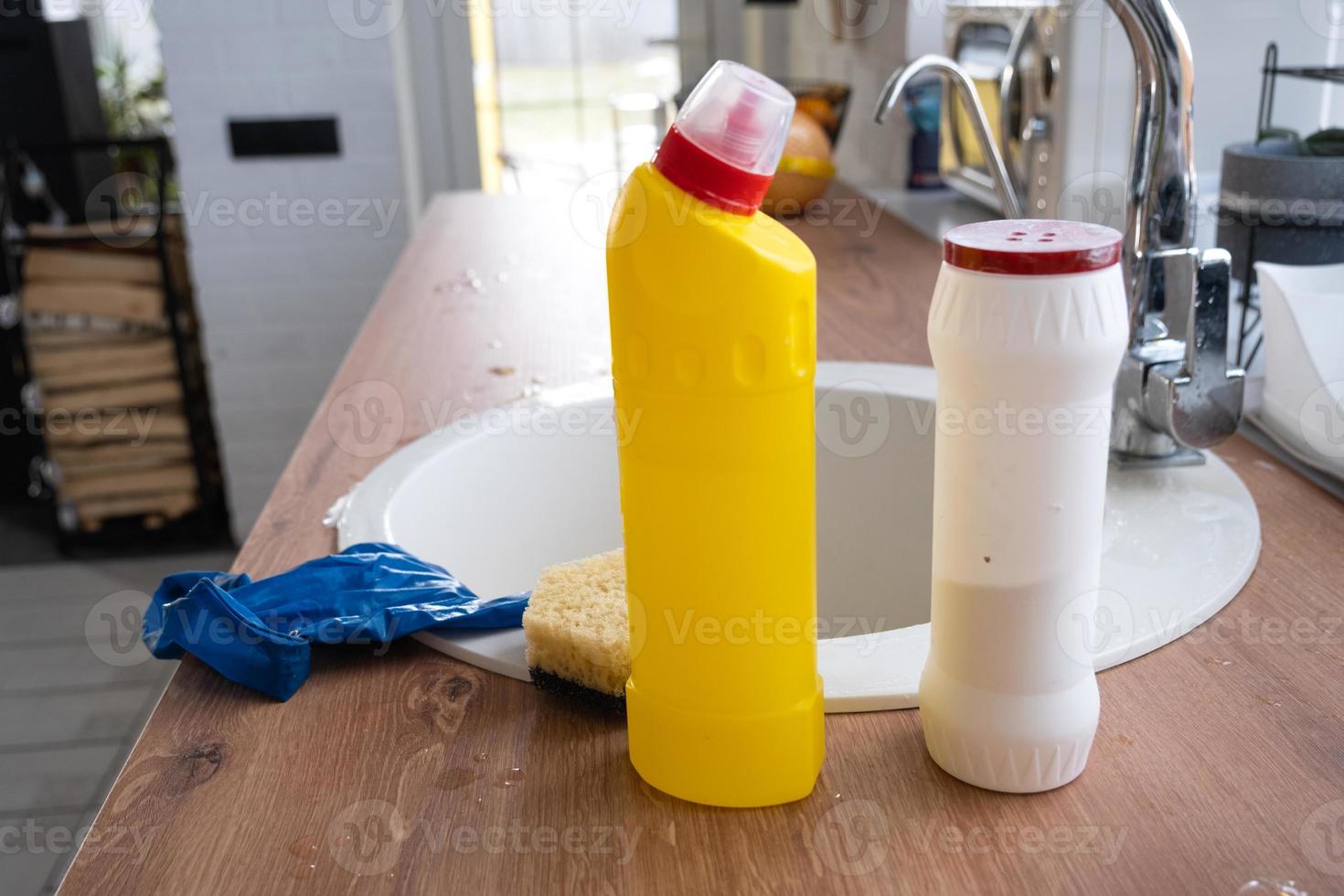 schoonmaak de keuken, wasmiddel, droog poeder, spons, handschoenen zijn Aan de wasbak. feestelijk decor in de wit keuken, knus interieur van de huis foto