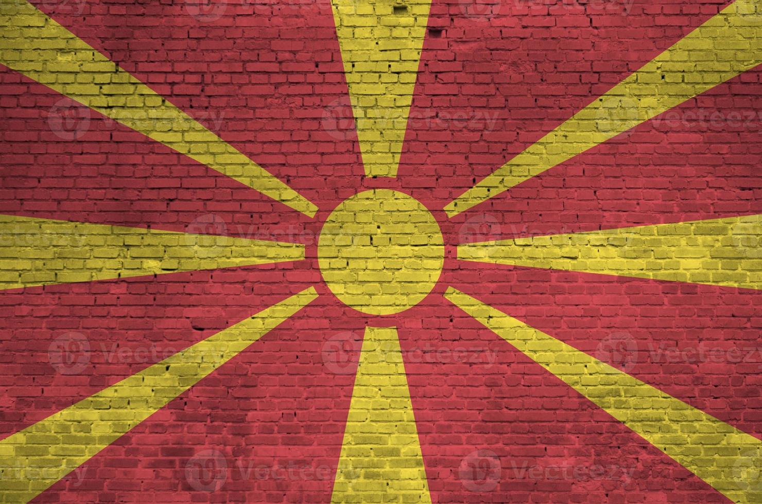 Macedonië vlag afgebeeld in verf kleuren Aan oud steen muur. getextureerde banier Aan groot steen muur metselwerk achtergrond foto