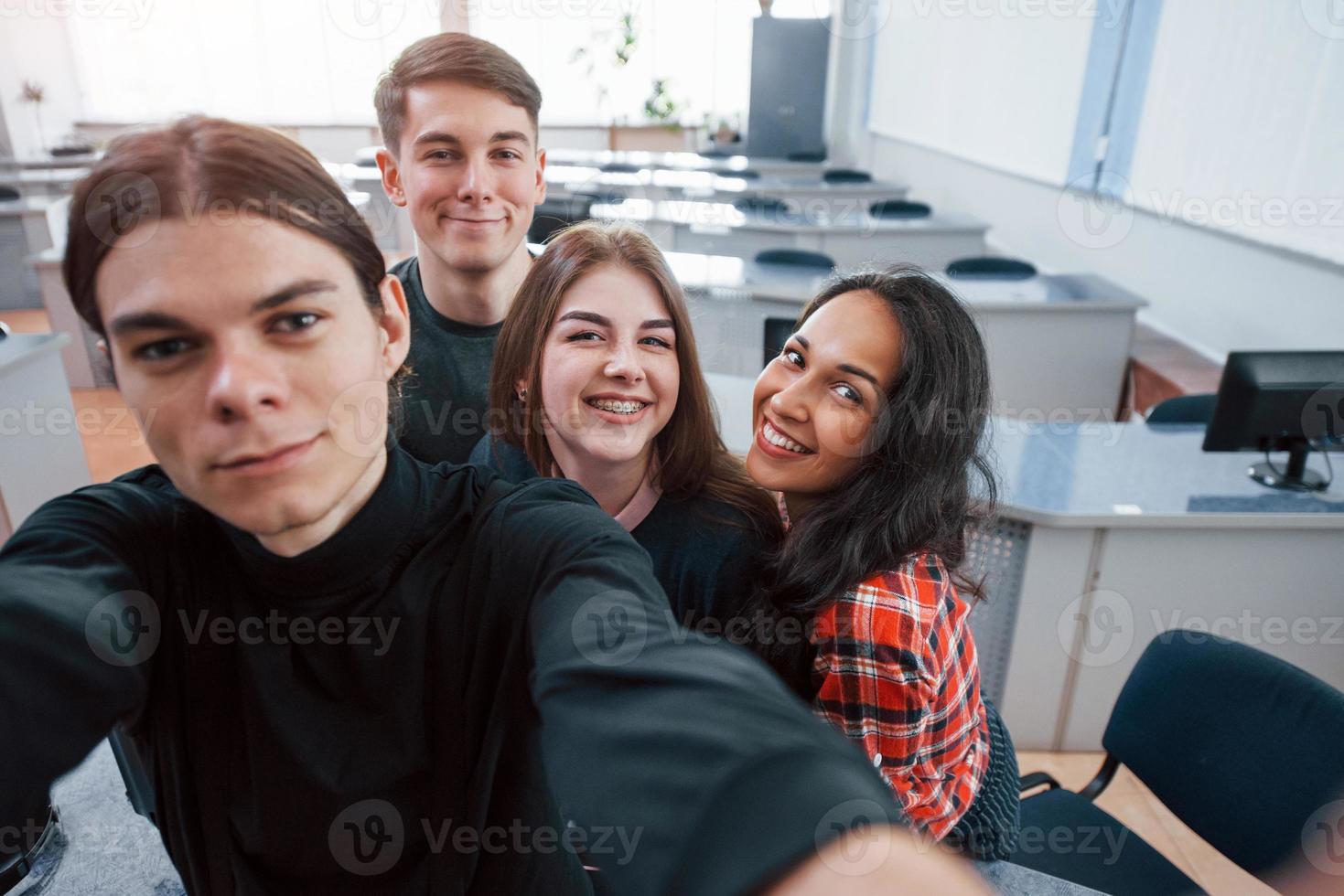 een selfie maken. groep jongeren in vrijetijdskleding die in het moderne kantoor werken foto