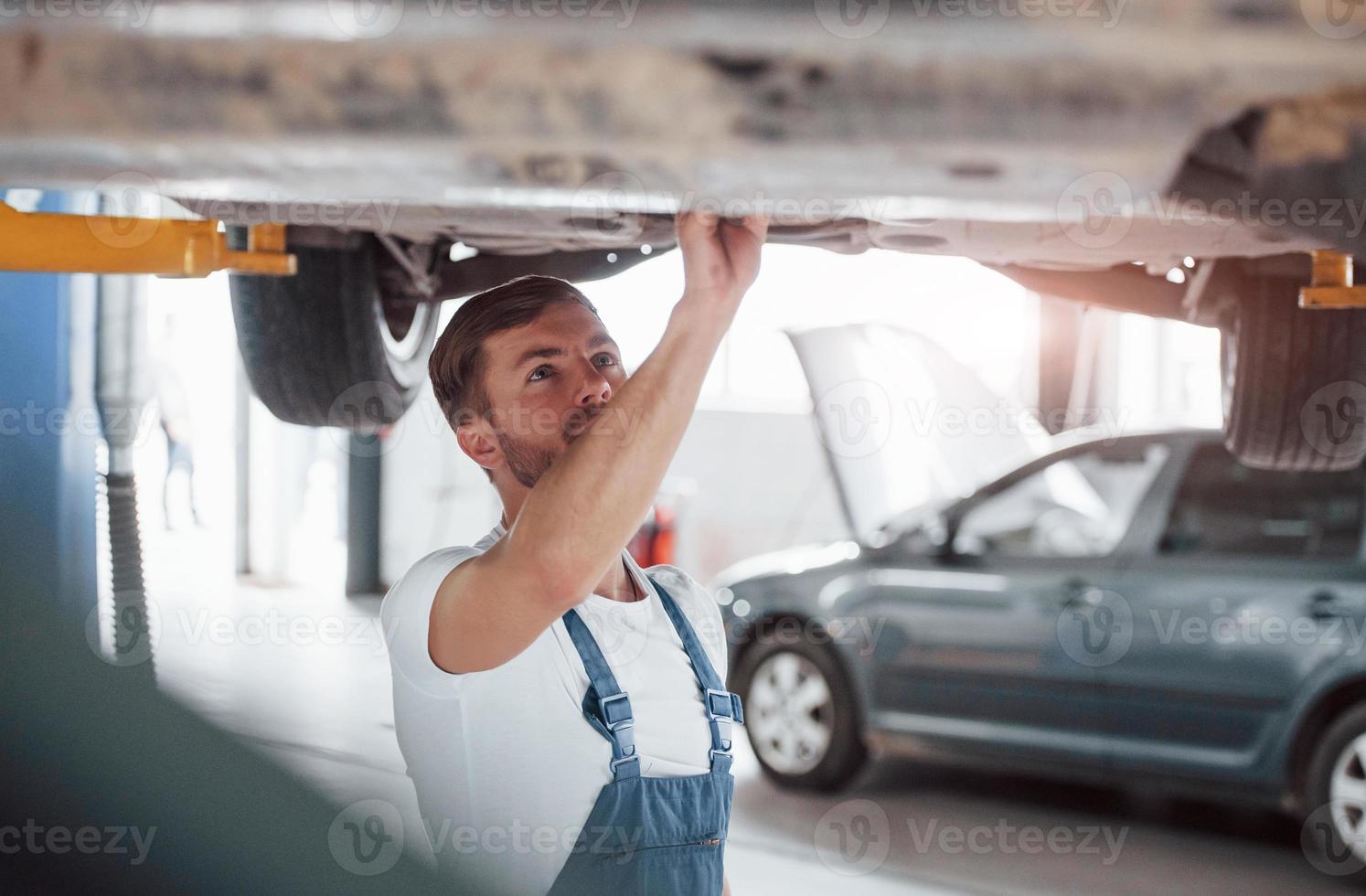 aandacht nodig. werknemer in het blauw gekleurde uniform werkt in de autosalon foto