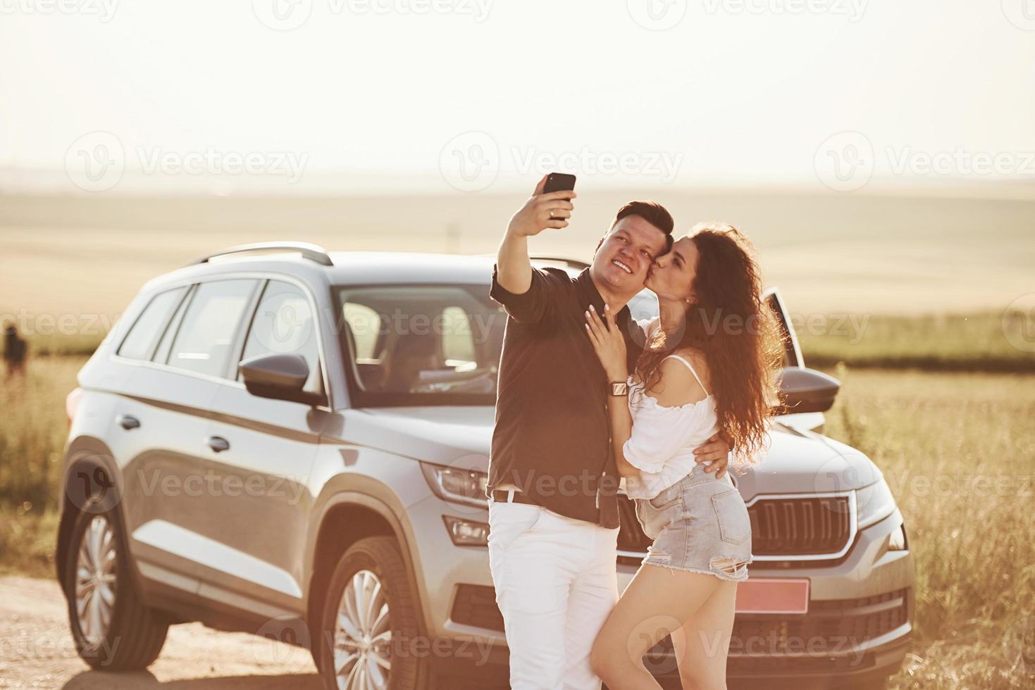 kus in de wang. lief paar in hun nieuw modern auto Bij weekend tijd foto