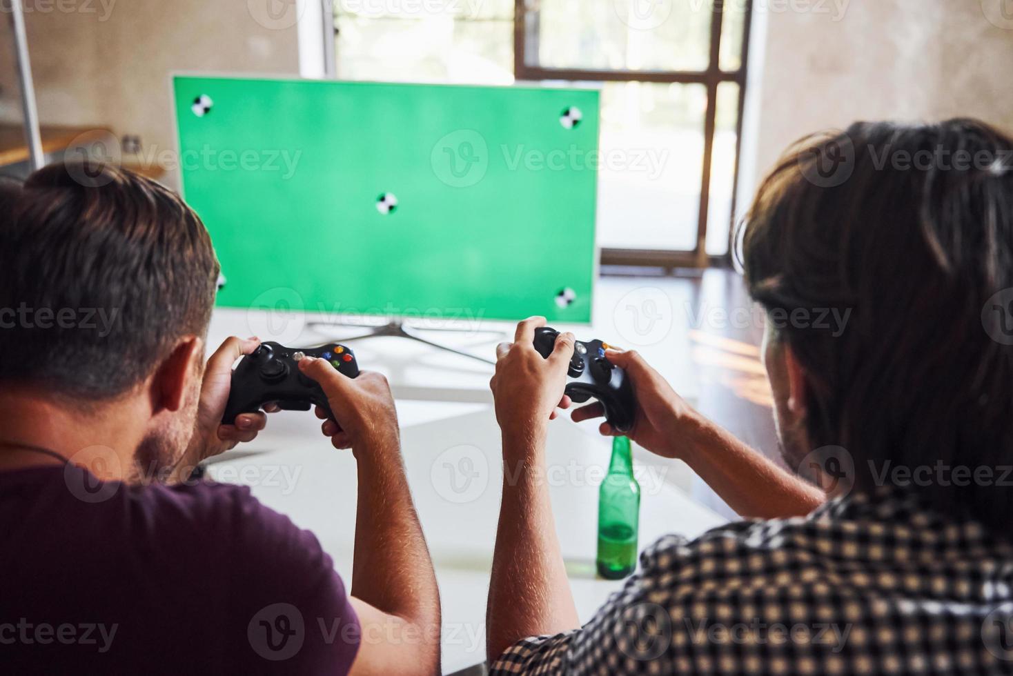 bier Aan de tafel. groep van vrienden hebben pret spelen troosten spel binnenshuis Bij leven kamer foto