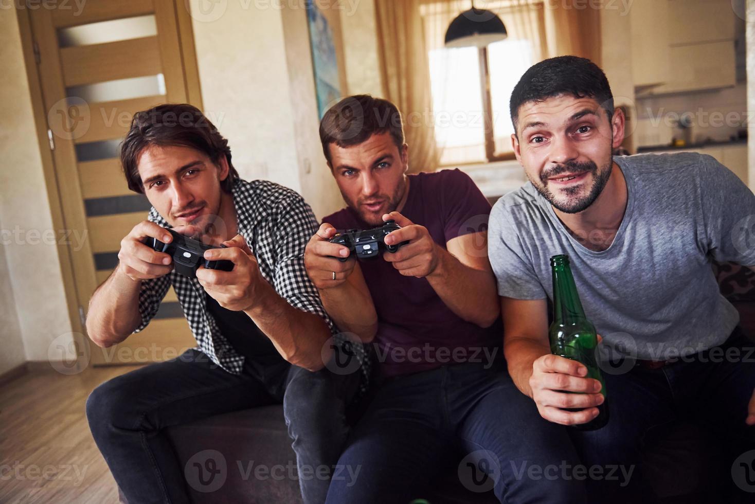 groep van vrienden hebben pret spelen troosten spel binnenshuis Bij leven kamer foto