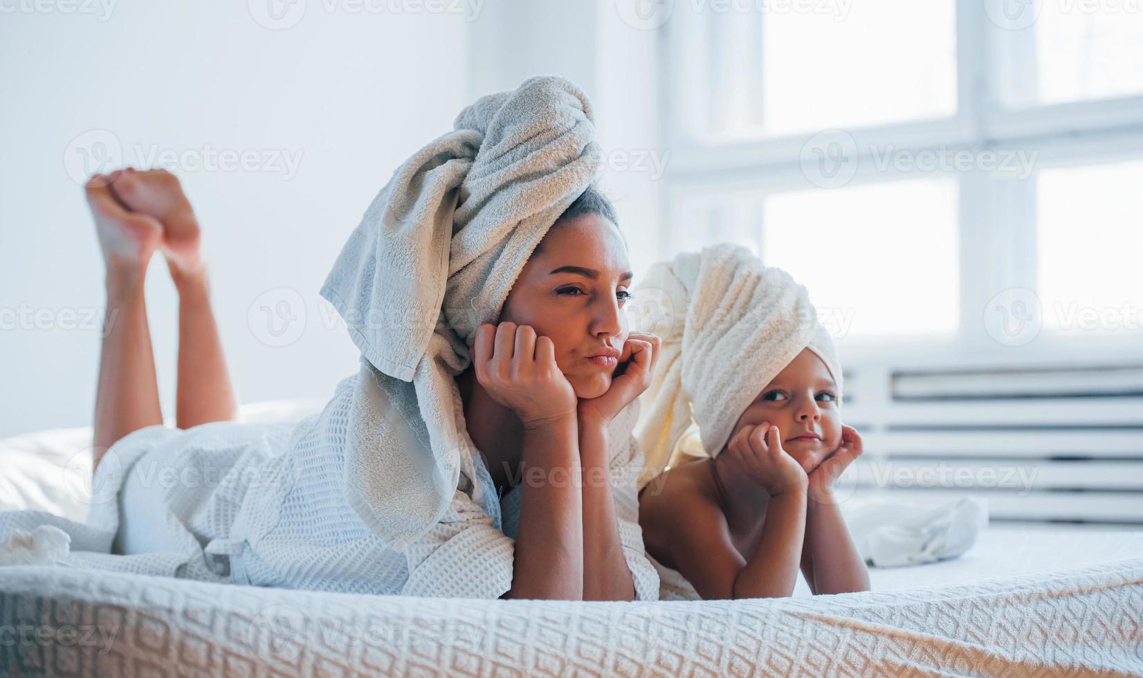 hebben plezier. jong moeder met haar dochter hebben schoonheid dag binnenshuis in wit kamer foto