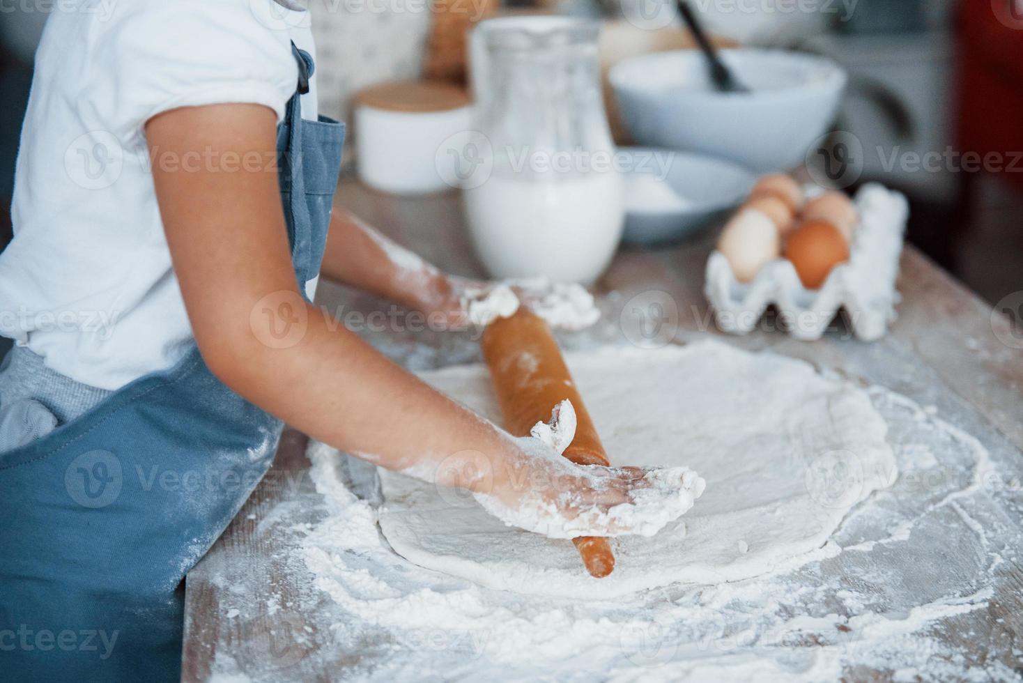 dichtbij omhoog visie. schattig kind in wit chef uniform voorbereidingen treffen voedsel Aan de keuken foto