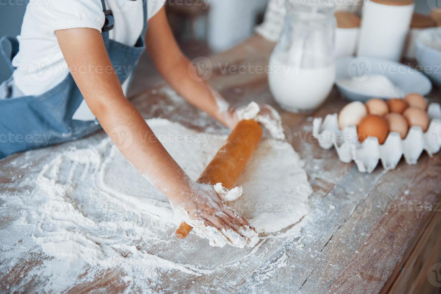 dichtbij omhoog visie. schattig kind in wit chef uniform voorbereidingen treffen voedsel Aan de keuken foto