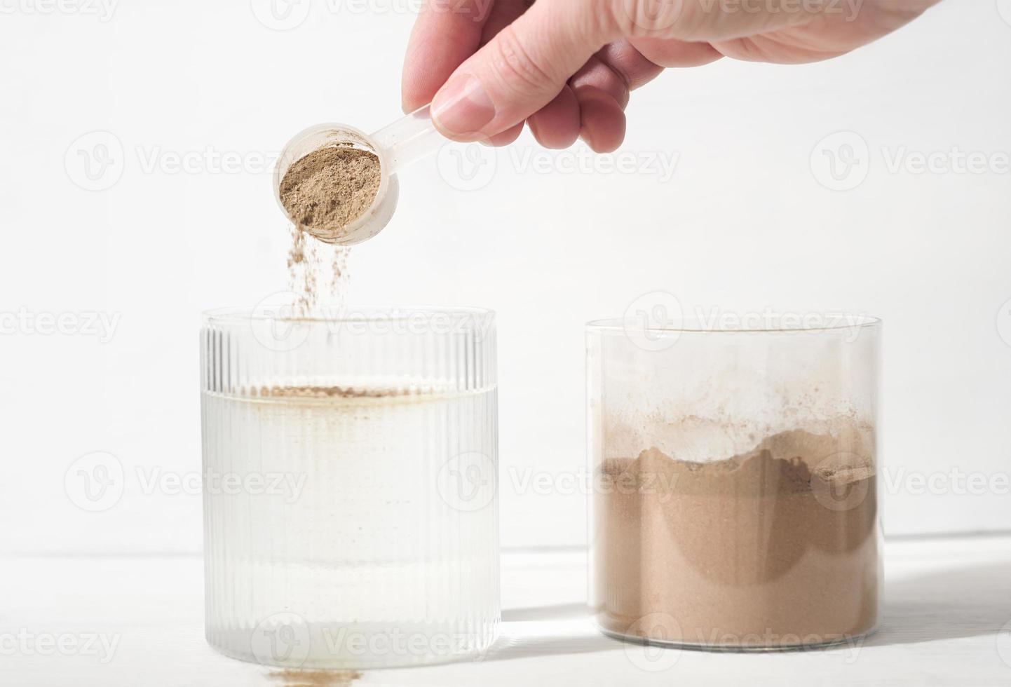 vrouw gieten fabriek gebaseerd eiwit poeder in een glas van water. fabriek eiwit net zo voedsel supplement, botten en gewrichten Gezondheid steun. foto