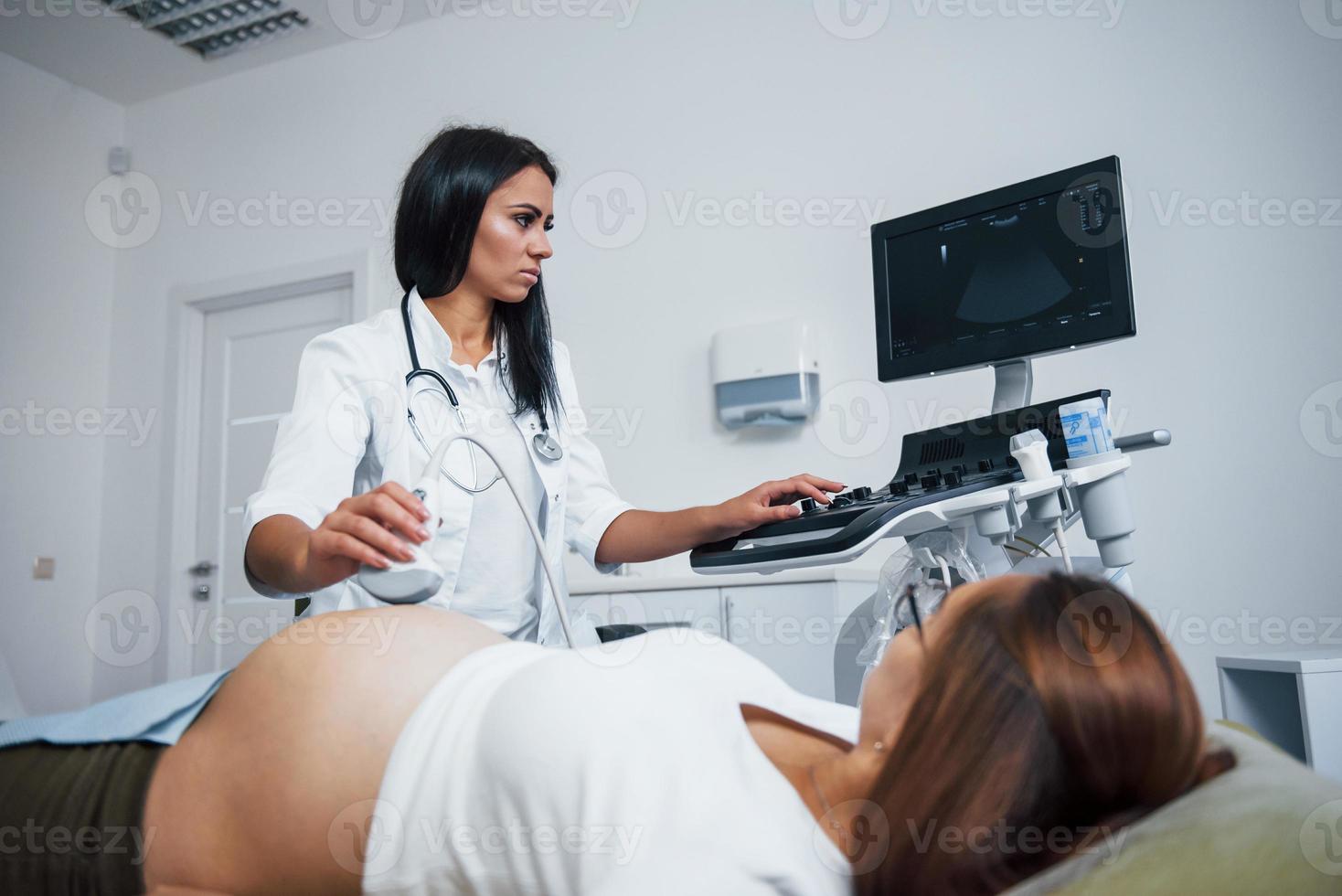 vrouw dokter doet echografie voor een zwanger vrouw in de ziekenhuis foto