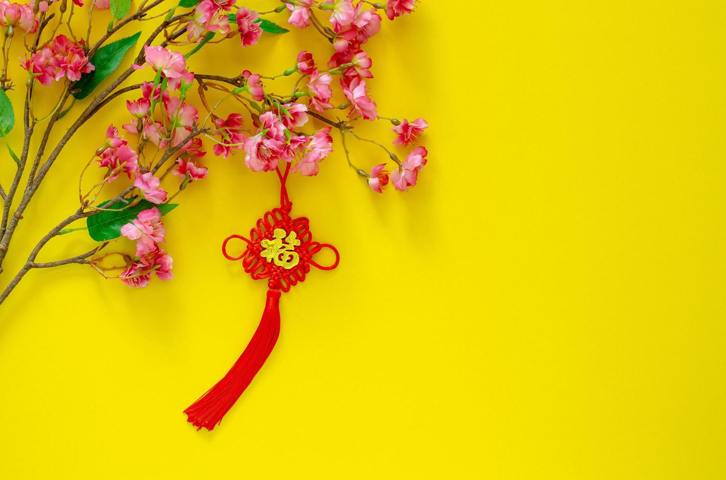 hangende hanger voor Chinese nieuw jaar ornament betekenis van woord is rijkdom met Chinese bloesem bloemen Aan geel achtergrond. foto