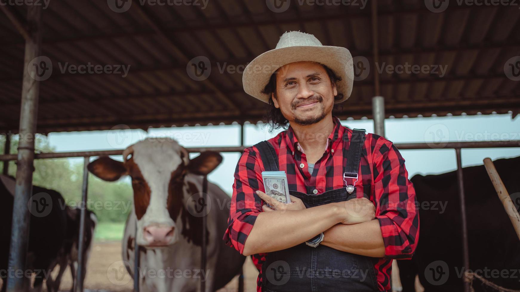 lachende en gelukkige boeren krijgen inkomsten van de melkveehouderij. landbouwindustrie, landbouw en veeteeltconcept, koe op melkveebedrijf die hooi eet. stal. foto