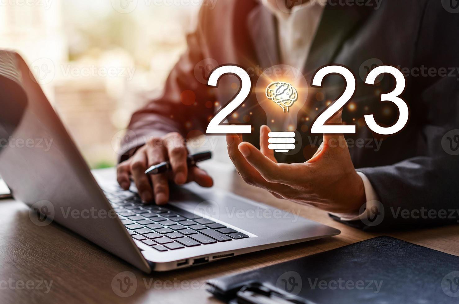 bedrijf mensen gebruik makend van laptop computer en Holding licht lamp voor succes bedrijf met 2023 nieuw ideeën en creatief innovatie concept foto