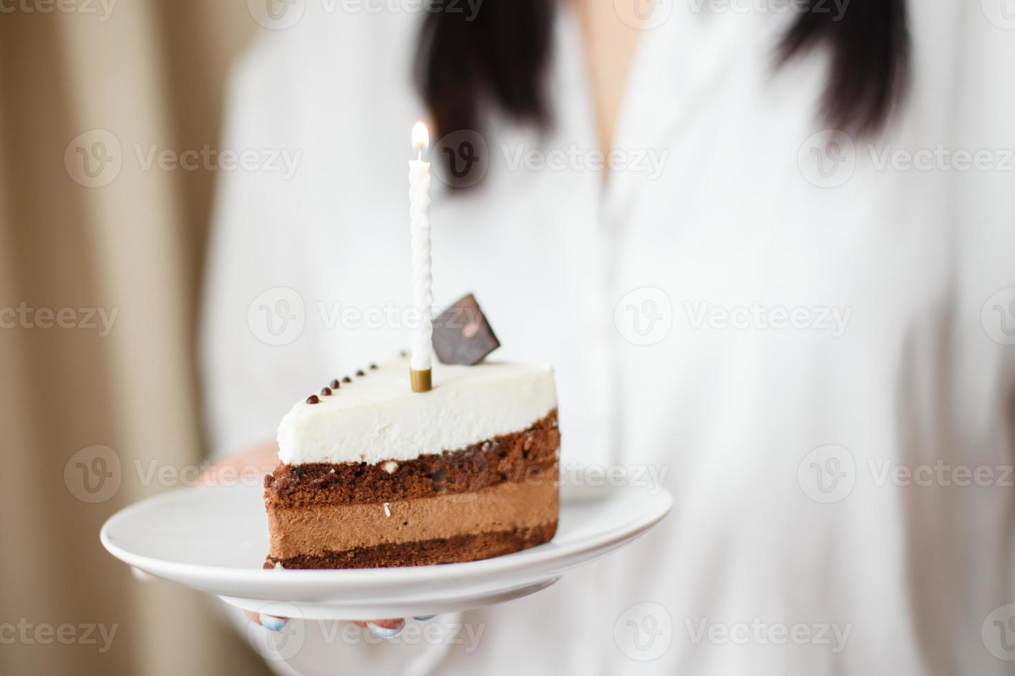 vrouw Holding stuk van taart met een kaars foto