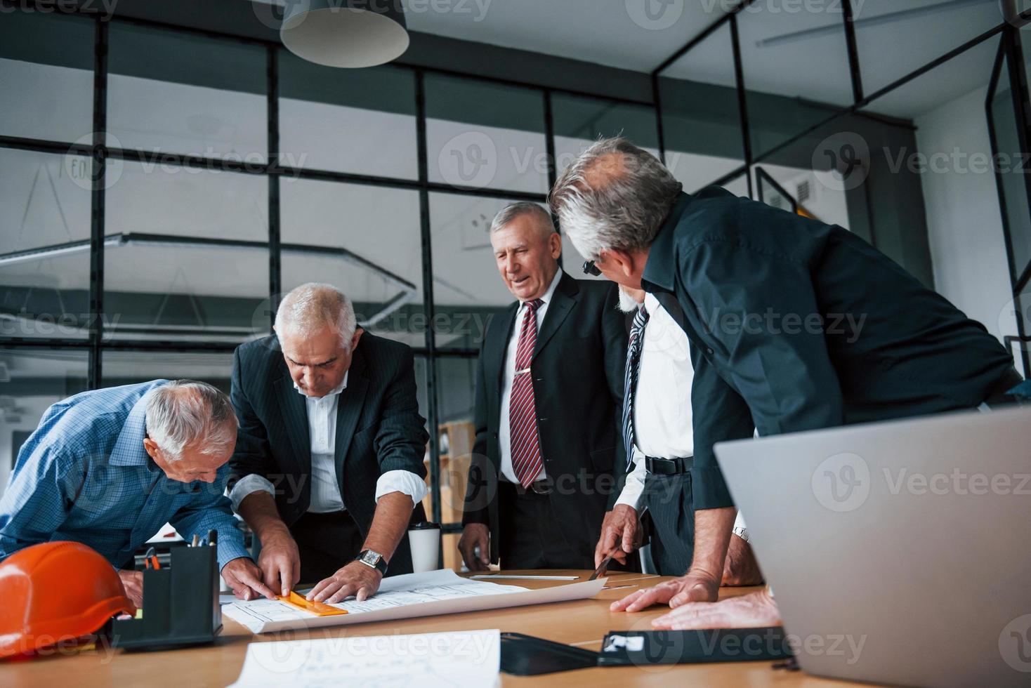 oud team van ouderen zakenman architecten werken met plan in de kantoor foto