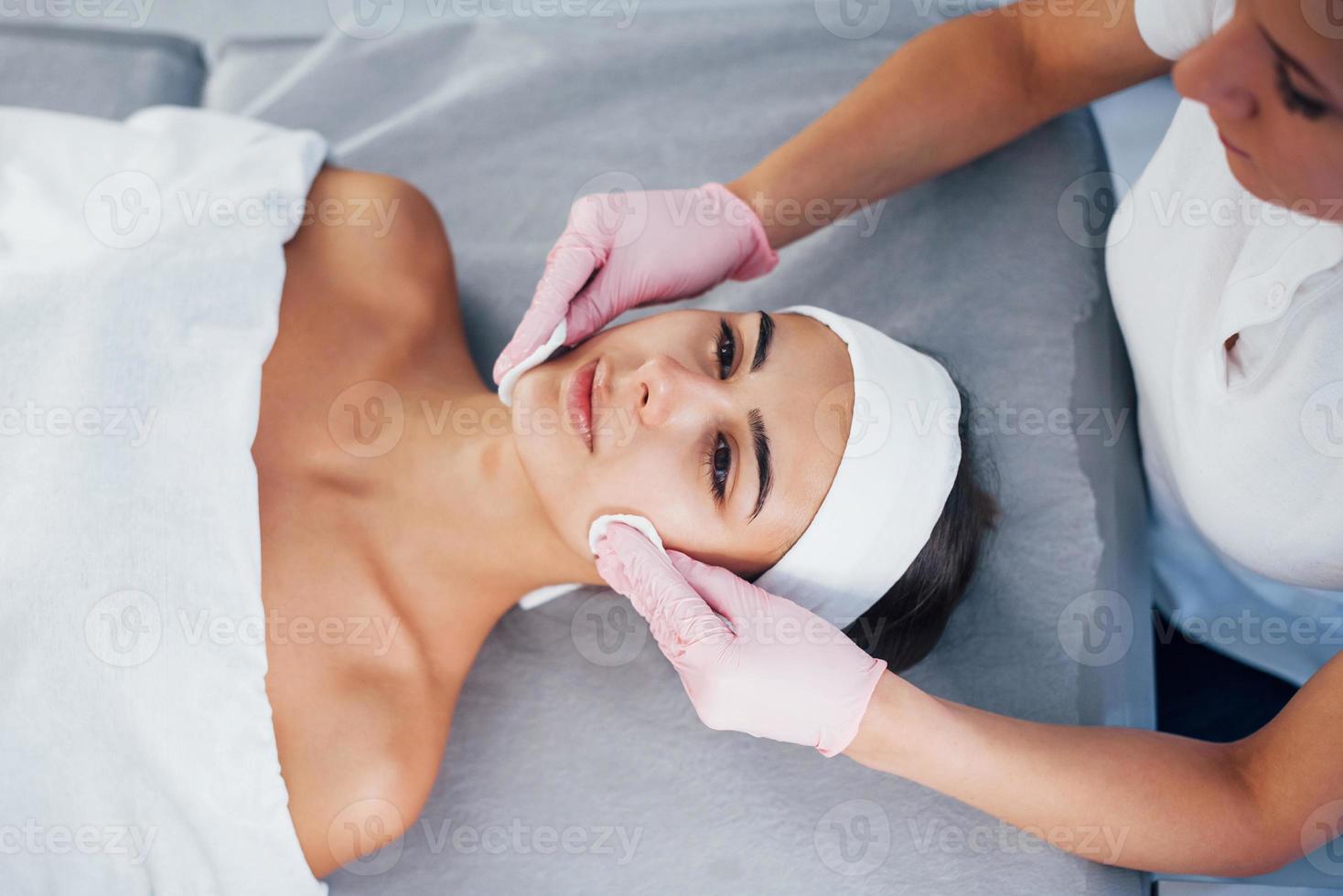 dichtbij omhoog visie van vrouw dat aan het liegen naar beneden in spa salon en hebben gezicht schoonmaak procedure foto