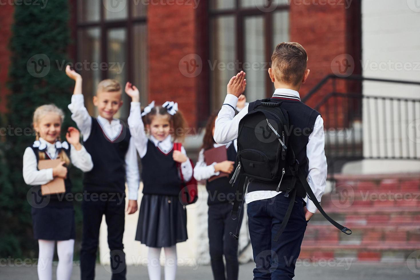 groep van kinderen in school- uniform dat is buitenshuis samen in de buurt onderwijs gebouw foto