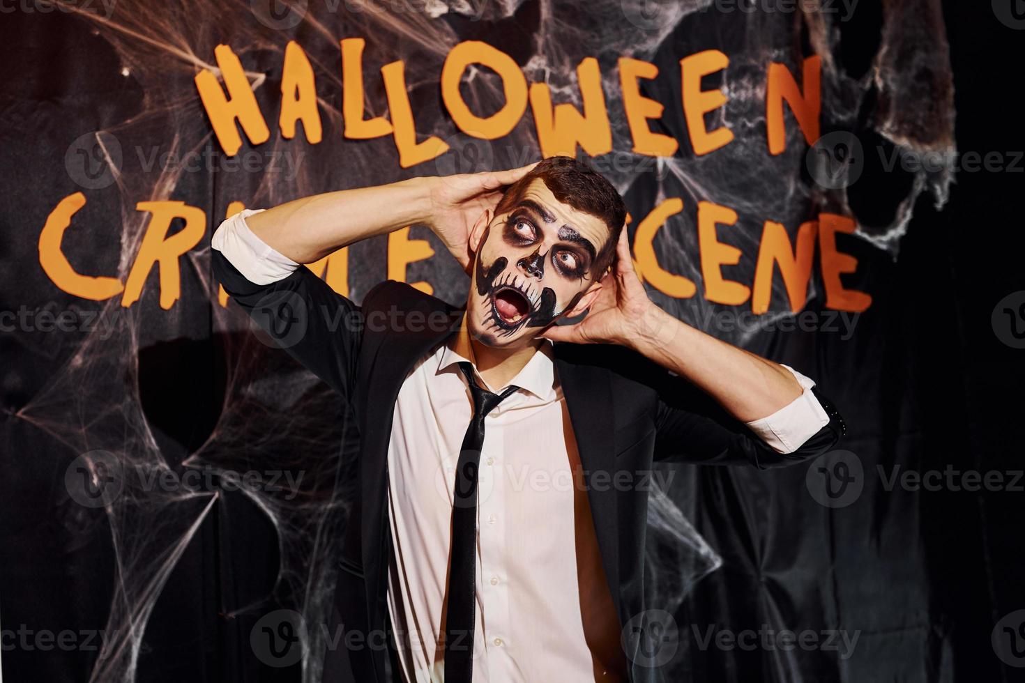 portret van Mens dat is Aan de thematisch halloween partij in eng skelet bedenken en kostuum tegen misdrijf tafereel muur foto