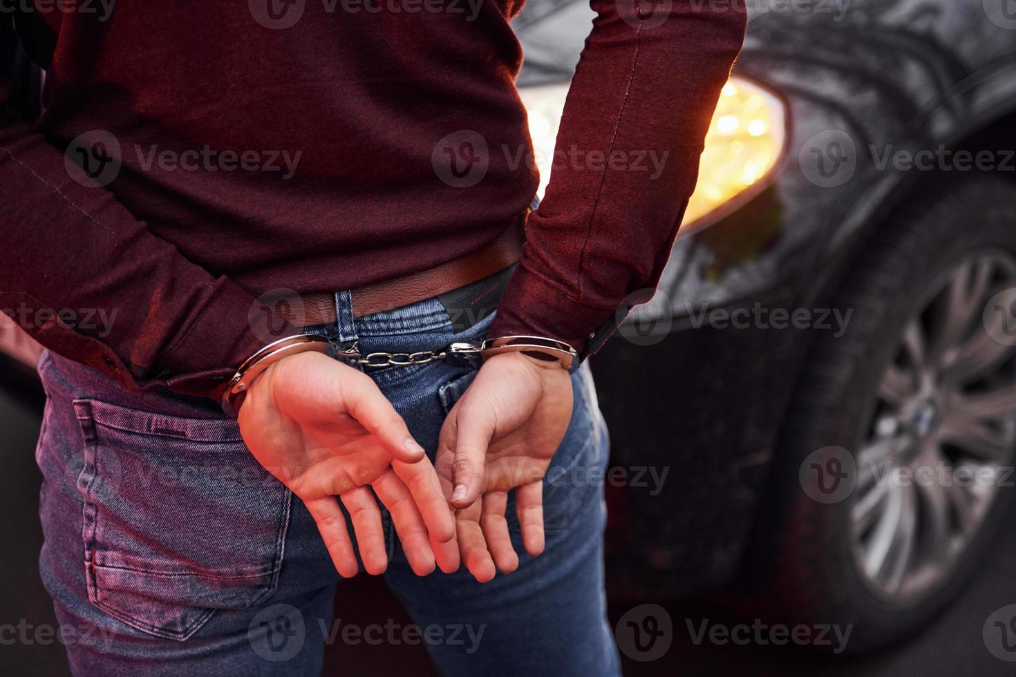 vrouw staand in handboeien in de buurt modern auto- buitenshuis foto