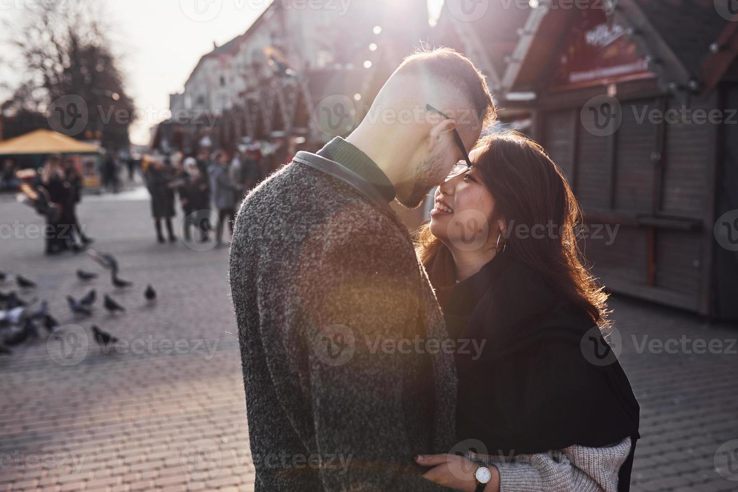 mooi zonlicht. gelukkig multiraciaal paar samen buitenshuis in de stad foto