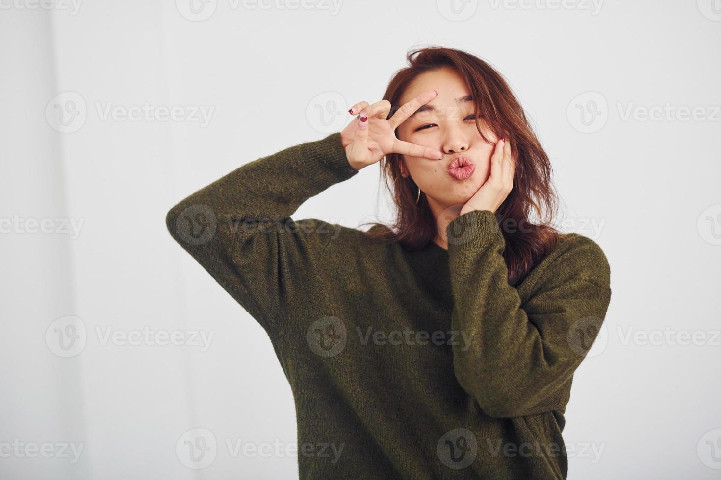 portret van gelukkig Aziatisch jong meisje dat hebben pret binnenshuis in de studio tegen wit achtergrond foto