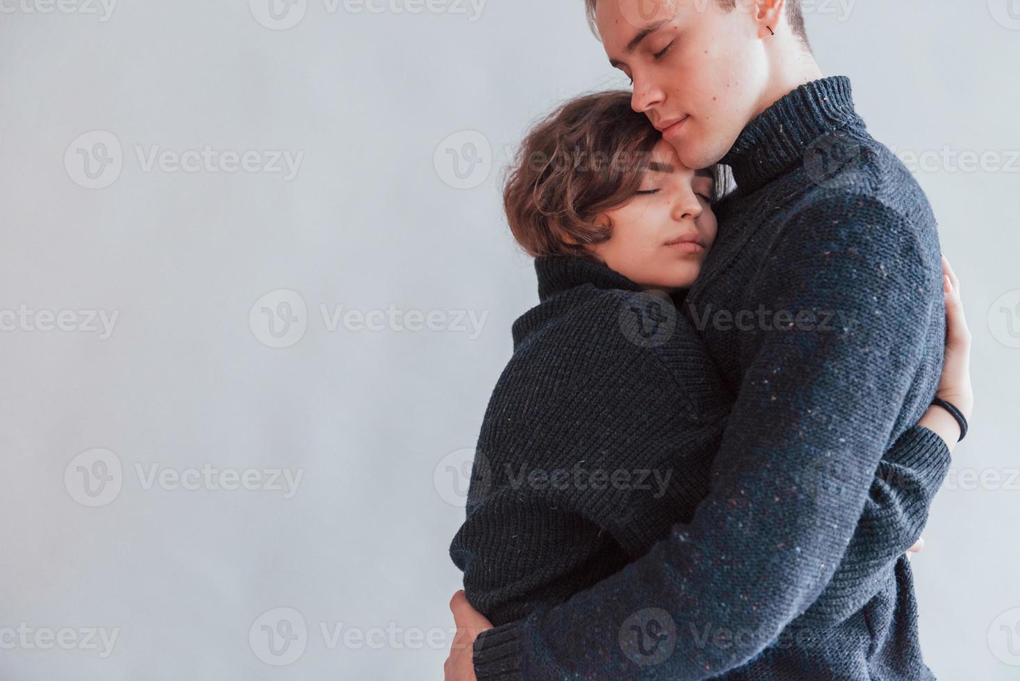 schattig jong paar omarmen elk andere binnenshuis in de studio foto