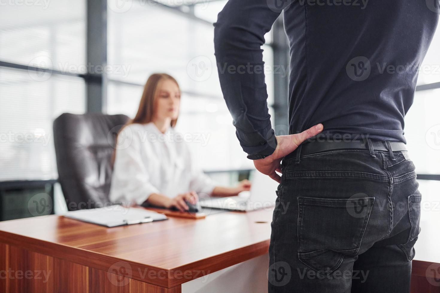 achterzijde visie. vrouw en Mens in formeel kleren werken samen binnenshuis in de kantoor door tafel foto