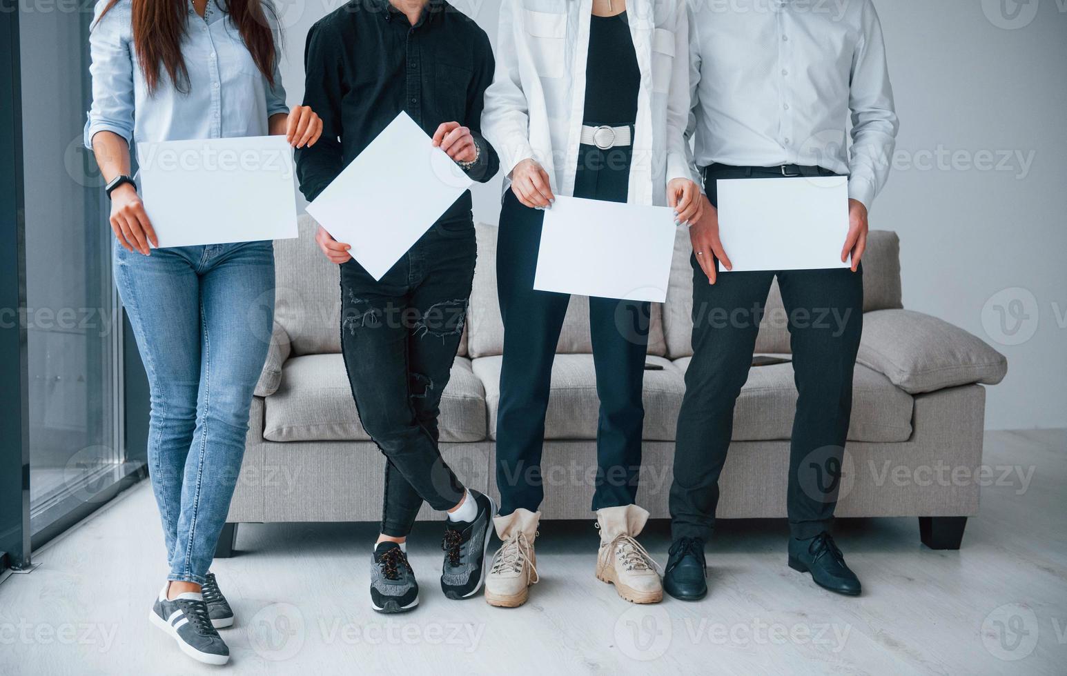 voorkant visie van jong groep van vrienden dat Holding leeg papieren in handen foto