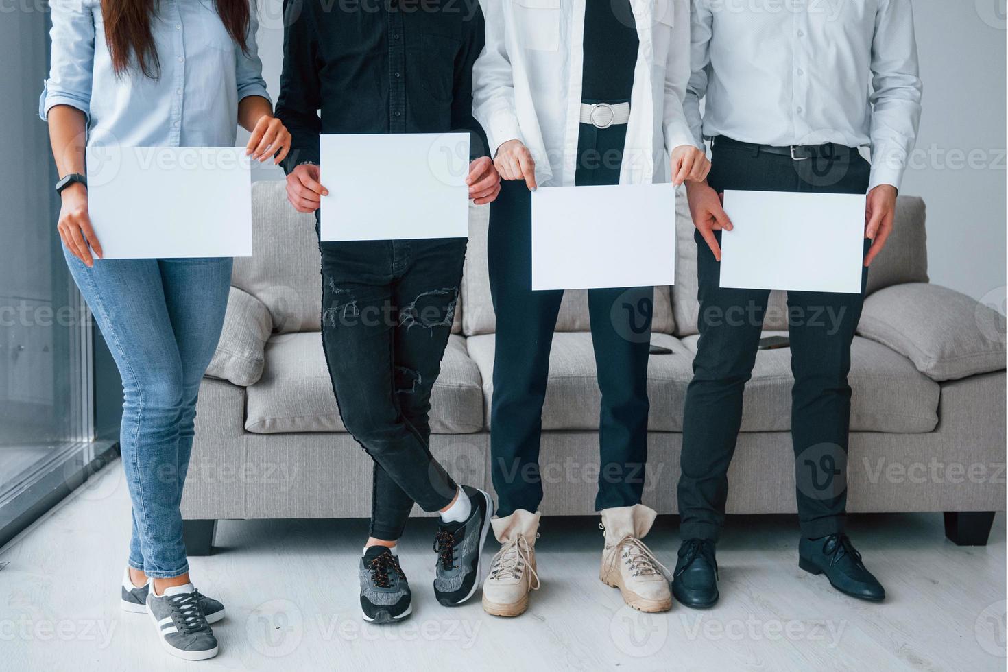 voorkant visie van jong groep van vrienden dat Holding leeg papieren in handen foto