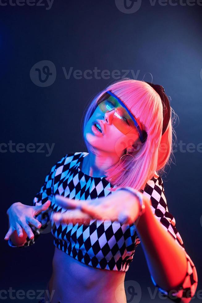 portret van jong meisje met blond haar- in bril in rood en blauw neon in studio foto