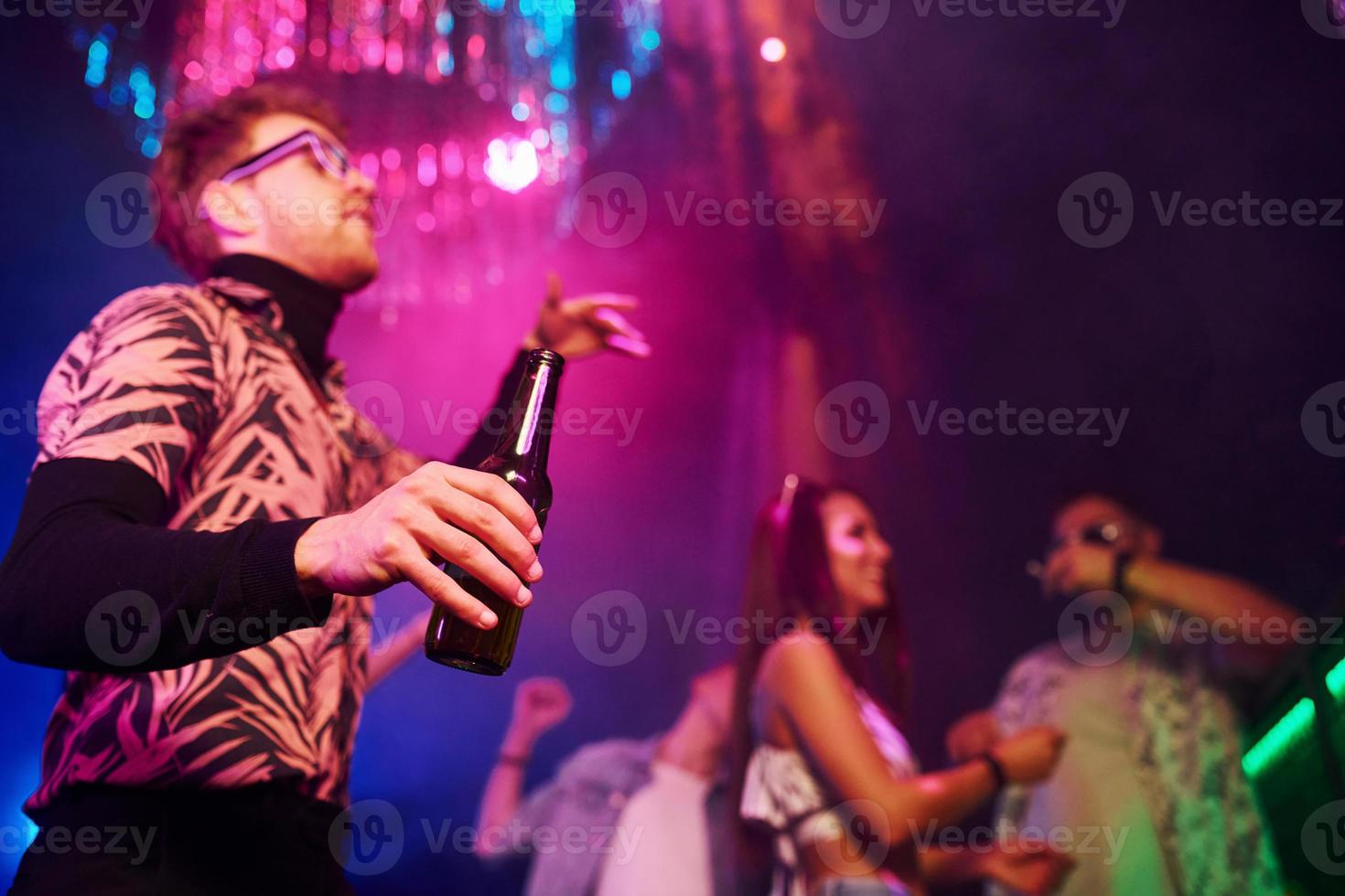 partij met alcohol. jong mensen is hebben pret in nacht club met kleurrijk laser lichten foto