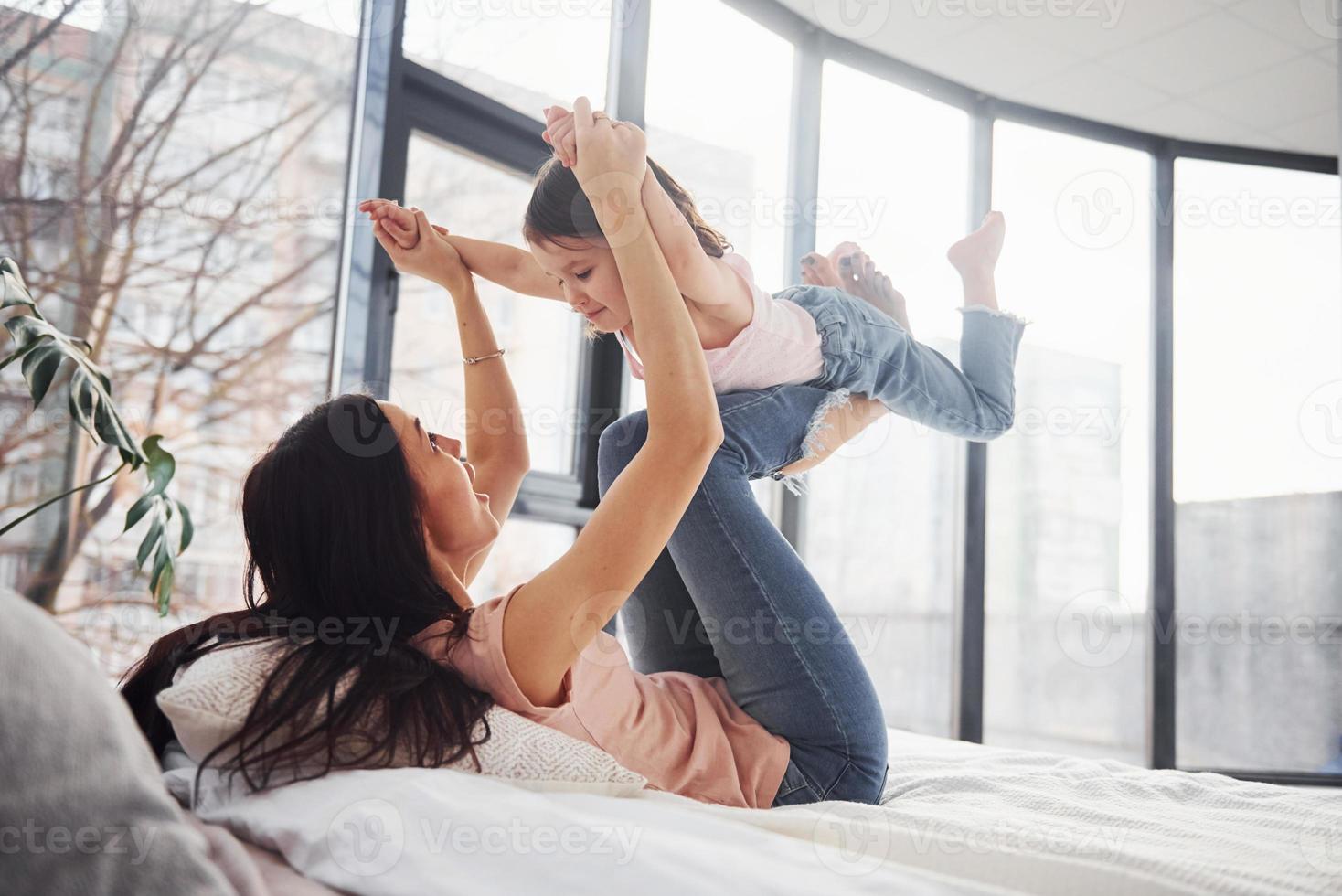 jong moeder met haar dochter uitgeven weekend samen Aan bed foto